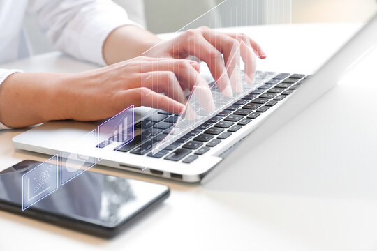 Two hands typing on laptop at desk (finance, investment related holographic projection)