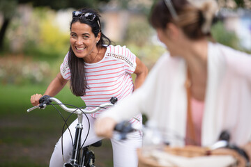 Fototapeta premium two beautiful women cycling in park