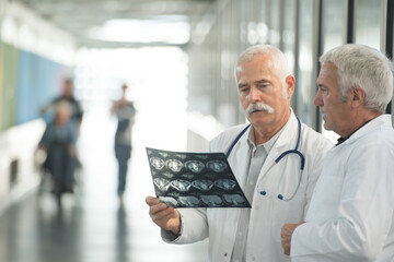 confident doctors holding xray report in hospital