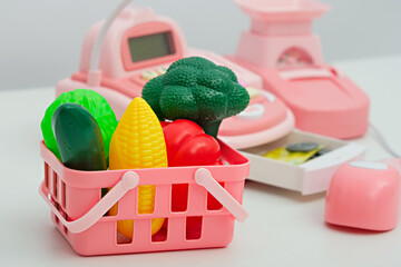 closeup of children's toy plastic vegetables in pink basket, children's play store, online grocery...