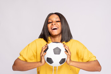 excited female african football fan holding a ball