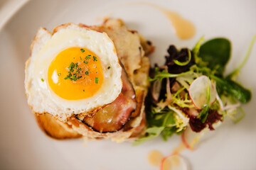 Croque Madame (toast topped with dry-cured ham, grilled cheese and a fried egg).