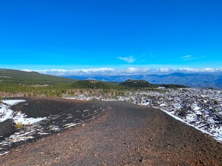 a wintery landscape with two craters on the Etna volcano on a clear sunny day in Sicily