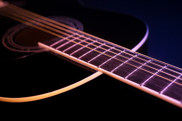 black guitar against a deep blue background. guitar music low-key concept