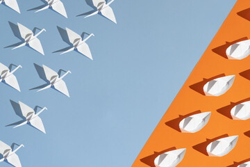 Minimal summer concept made of paper boats and birds. Modern origami aesthetic. Flat lay with sunny day shadow and copy space.
