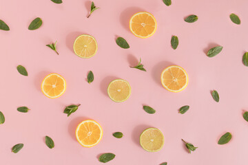 Summer pattern made of lemon and lime slices, and mint leaves on bright pink background. Minimal refreshment idea. Flat lay aesthetic.