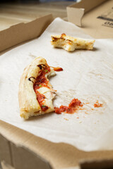 empty cardboard pizza box with pizza leftovers. After meal. Dirty dishes after dinner.