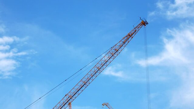  4K large construction site with several busy cranes at dusk with clear blue sky