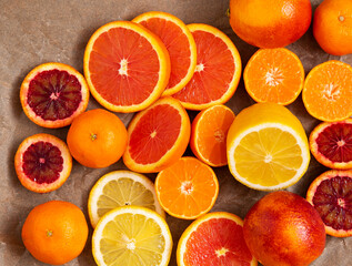 pieces of citrus fruits: orange, blood orange, lemon, tangerine on a background of crumpled craft paper. selective focus