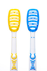 Yellow and blue tongue scraper isolated on a white background.