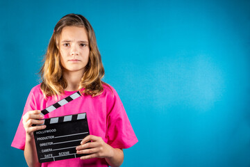 Serious girl with a clapperboard gives a signal about the start filming. Concept of cinematography,...
