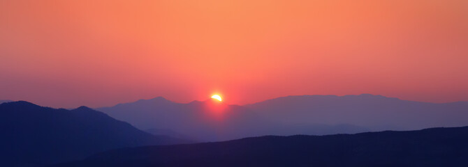 Naklejka na ściany i meble Majestic panorama of mountain landscape at sunset. Dramatic sky. Banner.