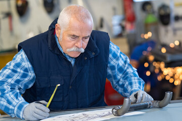 senior architect working on construction blueprint