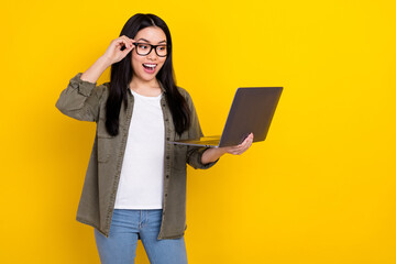 Photo of crazy overjoyed business lady online shopping see huge bargains isolated on yellow color background