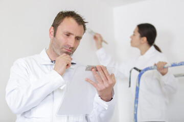 woman signing document in front of painter