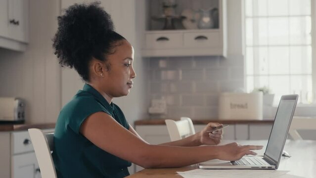 4k video footage of a woman shopping online using her laptop at home