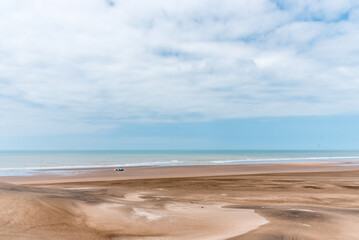 Landscape picture of the sands and dunes in front of the sea with some sky clouds. 