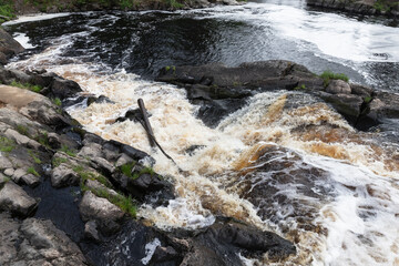 Abstract natural photo. Fast water goes over rocks