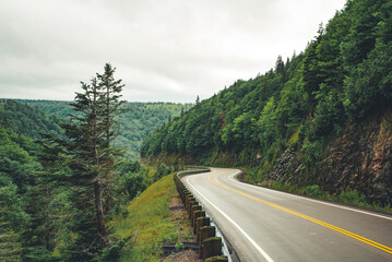 Scenic mountain winding road after the rain. Green forest hills in the background. Cape Breton, Cabot Trail, Nova Scotia, Canada © Sappheiros
