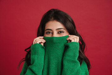 East asian woman hiding in sweater and looking at camera