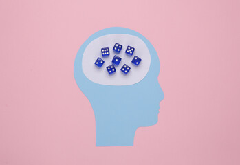 Paper cut head with dice for brain on pink background. Gambling addiction concept