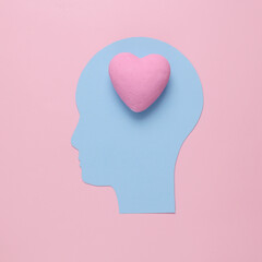Love concept. Paper cut head with heart instead of brain on pink background