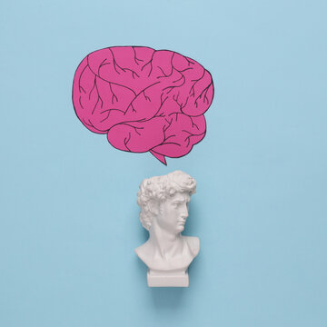 Bust of David with a paper-cut brain on a blue background. Intellectual, genius