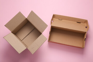 Open empty cardboard boxes on pink pastel background. Top view