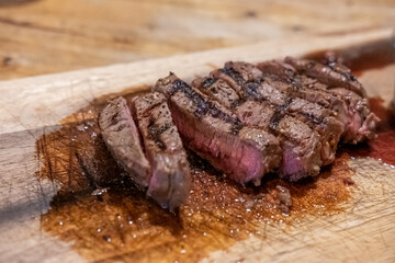 Medium rare meat on wooden plate
