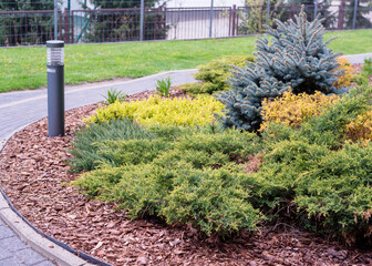 Obraz premium Luxury landscape design of the yard in Europe. Park outdoor landscape and exterior design. Green lawn, beautifully designed garden, territory near the house.