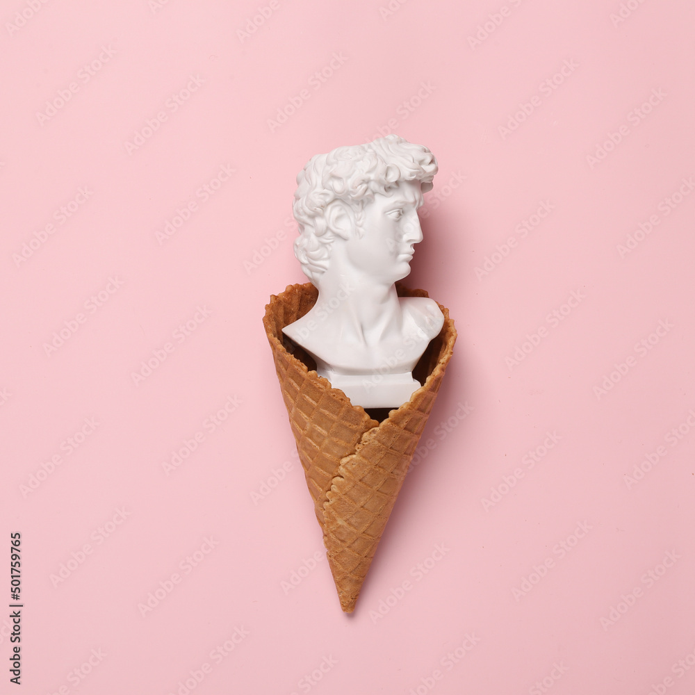 Wall mural creative minimal layout. waffle cone with david bust on a pink background. flat lay