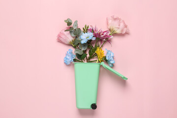 Romantic concept. Trash can with flowers on a pink background. Creative layout. flat lay