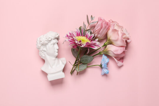David bust with flowers on pink background. Beauty, romantic concept
