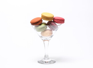 Minimal food still life. Cocktail glass with French macaroons on white background.