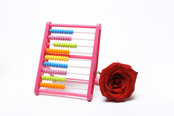 Abacus with red rose bud isolated on white background