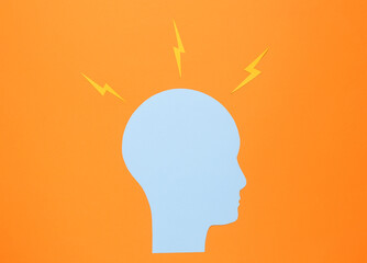 Paper cut human head with arrows on orange background. Headache, brainstorming or flow of ideas concept