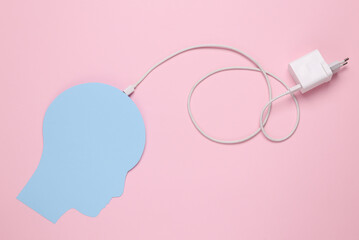 Recharge your brains. Paper-cut head with connected charger on pink background