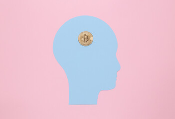 Paper cut head with bitcoin instead of brain on pink background