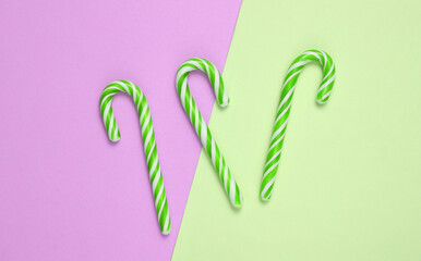 Christmas striped candy canes on pink green background.