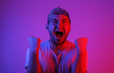 Emotional Bearded Man in foil hat in blue red neon light. - obrazy, fototapety, plakaty