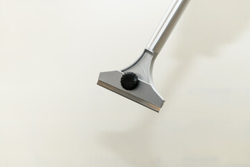 Construction scraper on gray wall background. Construction finishing works. Wall repair inside the...