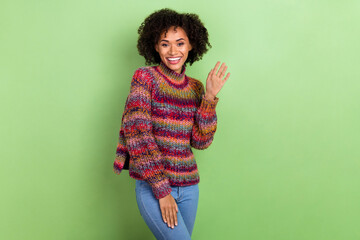 Photo of adorable positive girl arms palm wave hi beaming smile isolated on green color background © deagreez