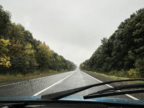 Picture of the road, taken from the windshield from the car. Road drive trip in autumn at rainy weather. Traveling in the car.