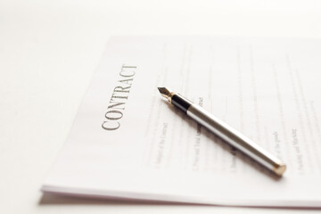 Ink pen lying on a contract or application form, low angle view.