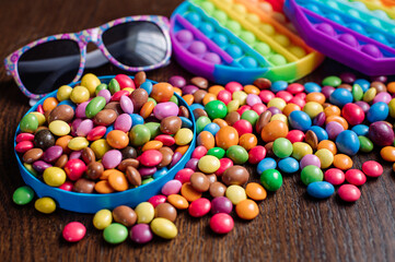 Many tasty little colored candies and pip it on wooden background
