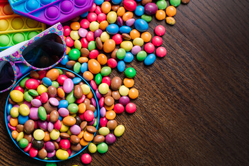 Many tasty little colored candies and pip it on wooden background