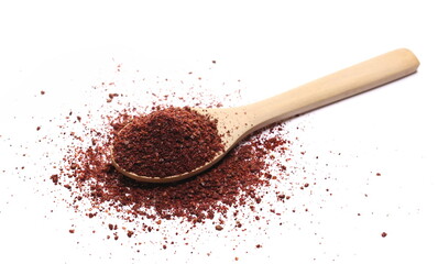 Ground sumac spice, pile in wooden spoon isolated on white 