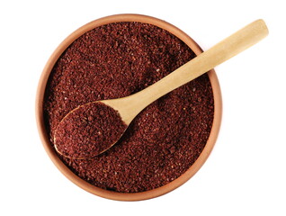 Ground sumac spice, pile in clay pot and wooden spoon isolated on white, top view 