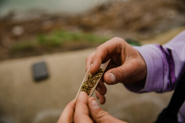 Hands of a man rolling a marijuana cigarette