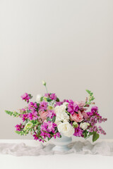 spring floral centerpiece with purple lilacs and pink roses inside